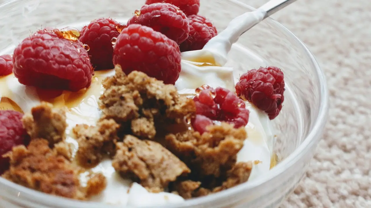 A bowl of creamy Greek yogurt topped with berries - a calcium and protein-rich snack for lactating mothers.