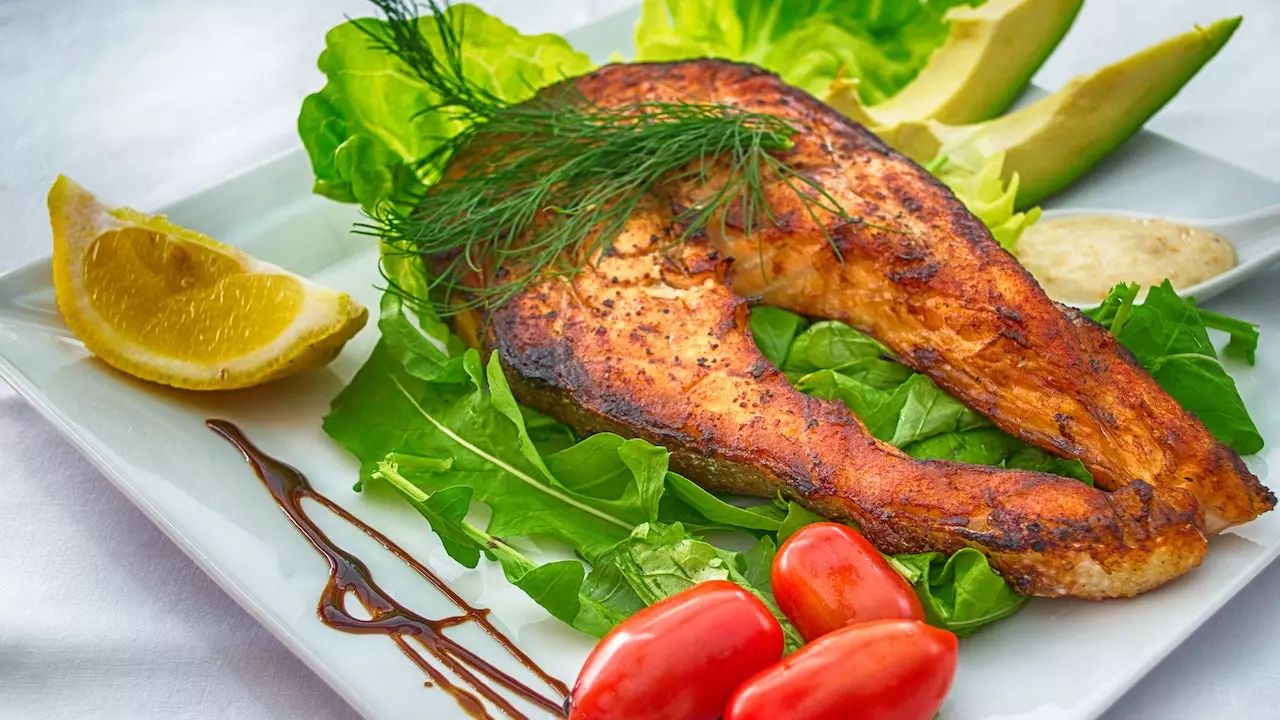 Grilled salmon on a plate with a side of greens.