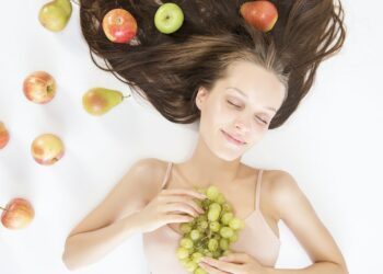 Woman with radiant skin holding a plate of assorted healthy foods